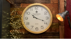 Reloj de pared grande Ø78cm, marco ancho de madera con acabado ligero, ambiente de estación