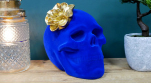 Calavera de resina con acabado azul zafiro, flor de nenúfar dorada con efecto envejecido, ambiente contemporáneo, 23cm